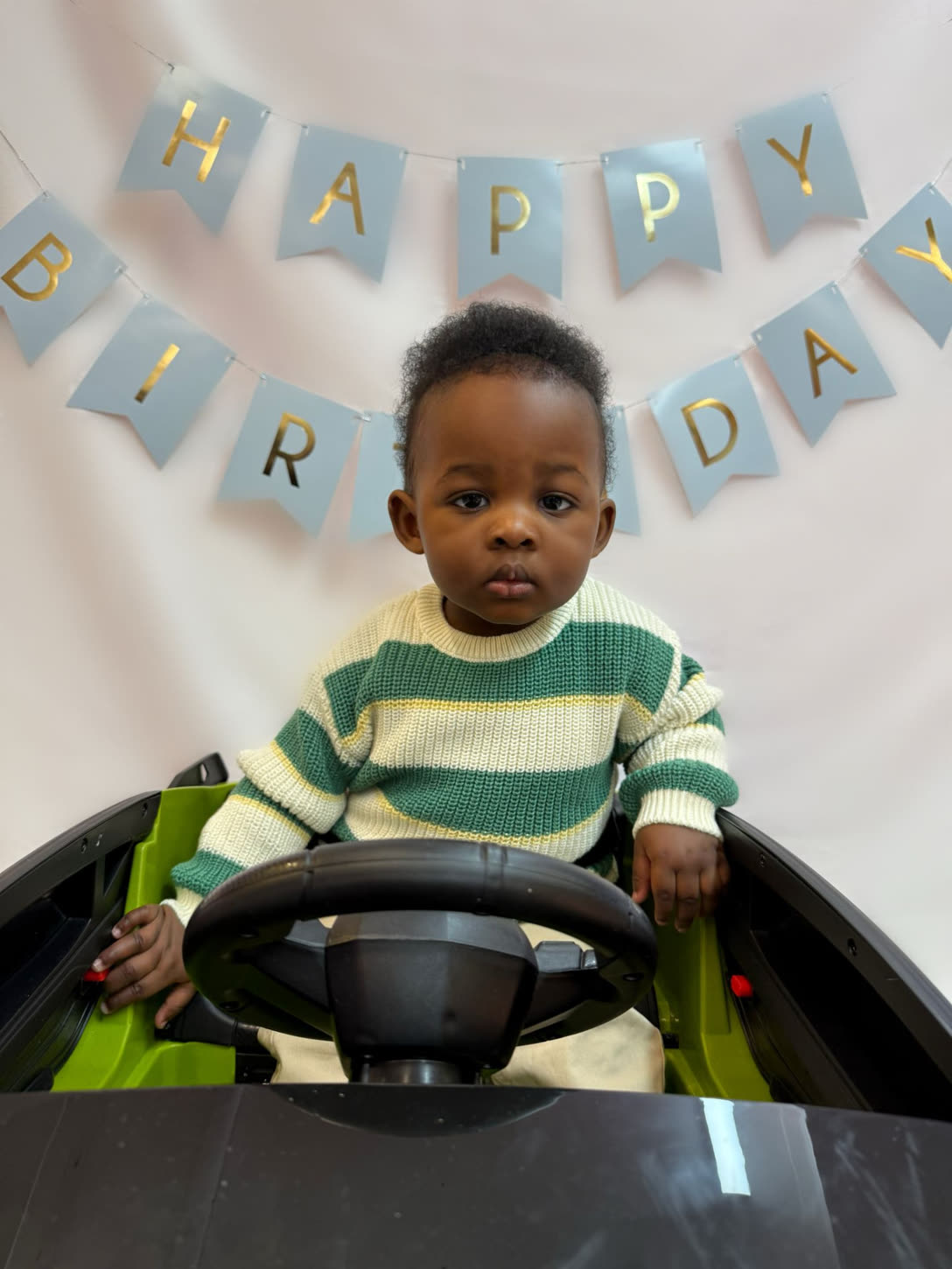 Birthday portrait in the ride-on car with happy birthday bunting