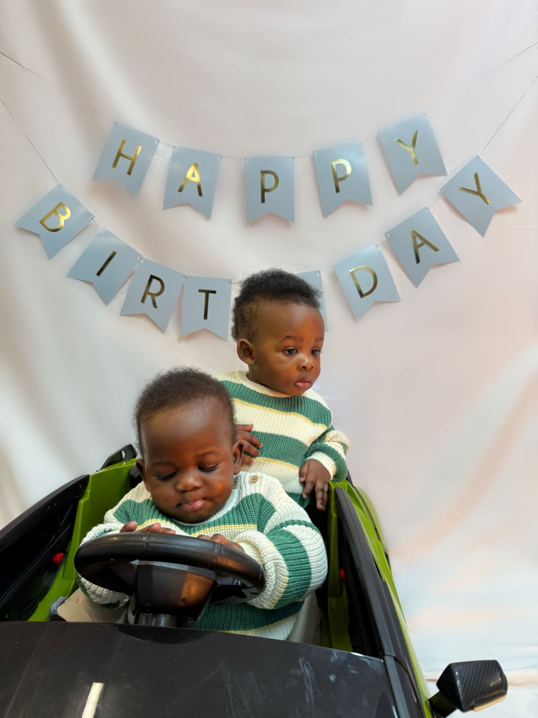 Twins birthday portrait in the ride-on car